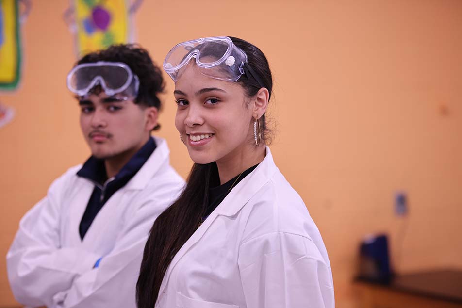 student in classroom smiling at camera